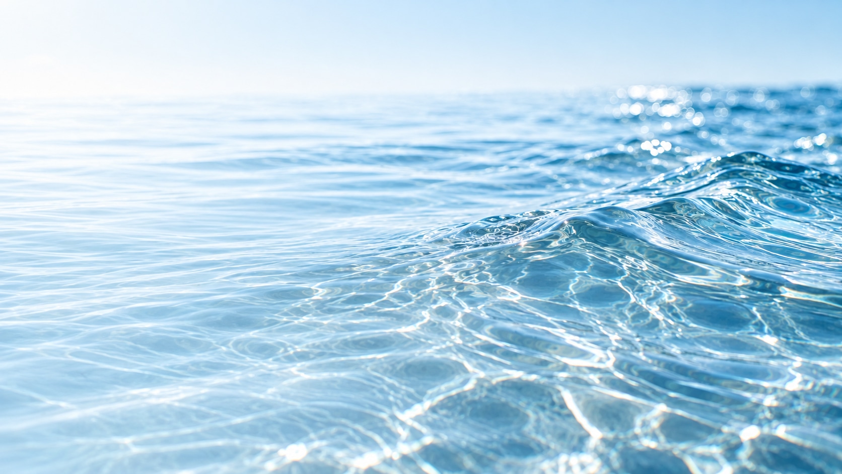 Symbolbild: klares, fließendes Wasser mit sanften Wellen in hellen Aqua- und Blautönen